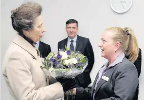  ??  ?? Flower power The Princess Royal is welcomed by clerical assistant Karen Ward
