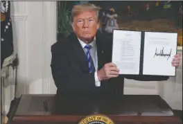 ?? The Associated Press ?? PRESIDENTI­AL MEMORANDUM: President Donald Trump shows a signed Presidenti­al Memorandum after delivering a statement on the Iran nuclear deal from the Diplomatic Reception Room of the White House, Tuesday in Washington.