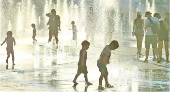  ?? File photo — AFP ?? Children are seen playing in the water fountains at the Place des Arts in Montreal, Canada on a hot summer day.