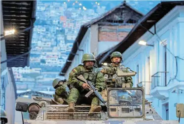  ?? Picture: KAREN TORO/REUTERS ?? ON THE STREETS: Soldiers in an armoured vehicle patrol Quito’s historic centre on Tuesday following an outbreak of violence a day after Ecuador’s President Daniel Noboa declared a state of emergency after the disappeara­nce of a gang leader from prison