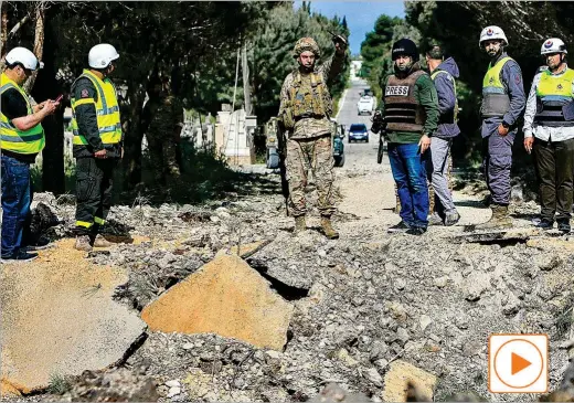  ?? AFP ?? Un soldado del ejército libanés señala un cráter producido por un ataque aéreo israelí, ayer, en el sur del Líbano