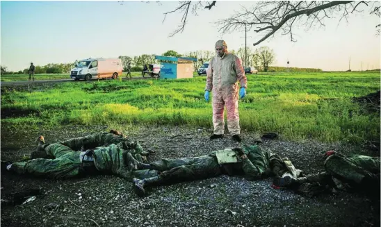  ?? REUTERS ?? Un voluntario frente a los cadáveres de los soldados rusos hallados en Vilkhivka