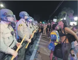  ?? AP PHOTO ?? Demonstrat­ors yell at police in El Cajon, Calif., as they protest the police shooting of Alfred Olango.