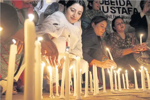  ??  ?? IN MOURNING: Pakistani people light candles for the victims of a suicide bomb attack that targeted the shrine of Sufi Muslim saint Lal Shahbaz Qalandar on Friday.