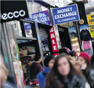  ?? BEN STANSALL / AFP / GETTY IMAGES ?? Retail outlets and shops on Oxford Street in central London in March. Recent data suggests British consumers are becoming more cautious in their spending.