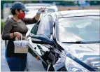  ?? BEN GRAY FOR THE AJC ?? CURBSIDE PICKUP: Katherin Cruz delivers an order during the lunch rush at Matthews Cafeteria on Main Street in Tucker in July.