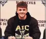  ?? Contribute­d photo ?? Coginchaug’s Owen Clancy signed his letter of intent to play baseball at American Internatio­nal College.