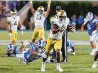  ?? BEN MCKEOWN/AP ?? Notre Dame’s Audric Estimé carries the ball past Duke’s Terry Moore for the eventual winning touchdown late in the second half Saturday night.