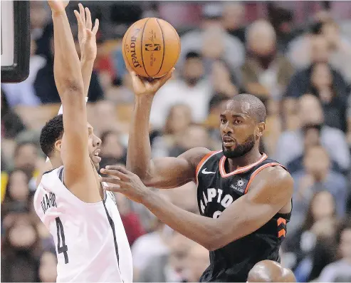  ?? FRANK GUNN / THE CANADIAN PRESS ?? Toronto forward Serge Ibaka passes the ball as Brooklyn centre Jahlil Okafor defends in Friday night’s game.