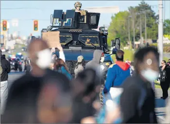  ?? KYLE TELECHAN/POST-TRIBUNE PHOTOS ?? An armored Lake County police vehicle follows behind protesters as they make their way down U.S. 30 May 31 in Hobart.