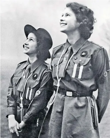 ?? ?? Queen Elizabeth II (right) and her younger sister Princess Margaret watch a carrier pigeon they have just released in February 1943. At the time the late Queen was a patrol leader in the Swallows
Five Eton Girl Guides demonstrat­e their prowess with the hose after completing a fire-fighting course early last century