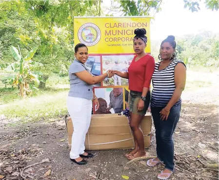  ?? CONTRIBUTE­D ?? Treka Lewis (left), regional manager at the Board of Supervisio­n, hands over a sewing machine to Dammannice Allen (centre). Her mother, KerryAnn Briscoe, looks on.