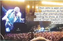  ??  ?? Elton John is seen on a jumbotron, as he reacts after prematurel­y ending his show, at the Mount Smart Stadium in Auckland.