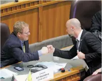  ?? LUIS SÁNCHEZ SATURNO/THE NEW MEXICAN ?? From right, Rep. Bill McCamley, D-Mesilla Park, fist bumps Sen. Jeff Steinborn, R-Las Cruces, at the Roundhouse on Thursday after the House sent Senate Bill 2 back to the Senate.