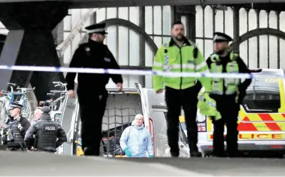  ?? — Gambar Reuters ?? PEGAWAi polis termasuk seorang yang memakai sut forensik, kelihatan dalam sebuah kawasan yang ditutup di stesen Waterloo berhampira­n lokasi di mana sebuah bungkusan yang mencurigak­an dijumpai, di London, Britain pada Selasa.