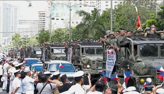  ??  ?? Home
at last: A convoy of Philippine marines passing by the Philippine Navy headquarte­rs upon disembarki­ng from the Philippine Navy amphibious ship BRP ‘ Tarlac’ in Manila.
— AP