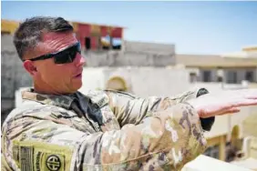  ?? THE ASSOCIATED PRESS ?? Col. Pat Work of the U.S. Army’s 82nd Airborne Division looks at the skyline as he meets with Iraqi commanders near the front lines on the roof of a house in Mosul on Friday.