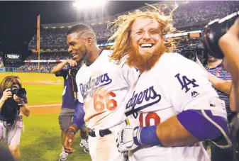  ?? Harry How / Getty Images ?? Justin Turner celebrates after his three-run, game-ending home run against John Lackey in Game 2 of the NLCS kept the Dodgers unbeaten in the postseason.