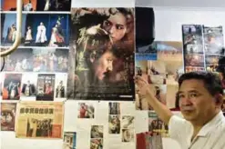  ??  ?? Taiwanese “qipao” maker Chen Chung-hsin pointing at a movie poster for “The Assassin” at his studio in Taipei.