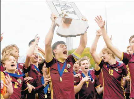  ?? SUZANNE TENNANT/POST-TRIBUNE PHOTOS ?? Senior defender Jack Eaton, middle, one of Chesterton’s tri-captains, lifts the Class 3A championsh­ip trophy on Saturday. It is Chesterton’s first state title after runner-up finishes in 2007 and 2016.