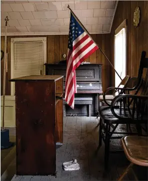  ?? ?? An old piano, a lectern, an American flag and some chairs can be seen inside the 97-year-old building that was the home in Chickamaug­a of the Prince Hall Masons, Lodge No. 221.