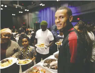  ?? STAN BEHAL ?? Sprinter Andre De Grasse serves families at a Thanksgivi­ng Day lunch on Monday in Toronto.