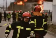  ?? Joe Raedle / Getty Images ?? Firefighte­rs battle a blaze in an industrial area of Lviv, Ukraine, ignited by a Russian rocket strike.