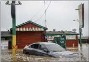  ?? BRONTË WITTPENN — SAN FRANCISCO CHRONICLE VIA AP ?? Floodwater from a breached levee submerges cars and floods businesses on Salinas Road in Pajaro, Calif. on Tuesday. The levee failure prompted overnight evacuation­s March 10into the next day.