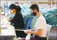  ??  ?? Workers at F.A.B.R.I.C., a non-profit organizati­on providing resources for emerging fashion designers, make PPE for area Dignity Health employees due to the coronaviru­s Monday, April 13, in Tempe, Ariz. F.A.B.R.I.C. is working around the clock to create thousands of FDA approved isolation gowns for workers on the
front lines of the pandemic. (AP)