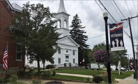  ?? JOHN SEEWER — THE ASSOCIATED PRESS ?? A flag rests at half-staff and a veterans banner rests outside the United Church of Christ in Berlin Heights, Ohio. Maxton Soviak, a U.S. Navy Fleet Marine Force hospital corpsman, was killed Thursday in Afghanista­n. Soviak lived in Berlin Heights.