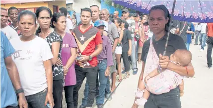  ??  ?? East Timorese queue at a polling station to vote in the presidenti­al election in Dili yesterday. A former guerrilla fighter is tipped for victory after winning the backing of the two biggest parties in a new sign of stability for Asia’s youngest nation.