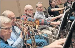  ??  ?? Profession­al trombonist Rick Howenstine, in plaid, working with amateur musician Eric Aho, right