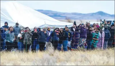  ?? ?? Chippewa Cree tribal members snap photos as they watch the bison release in Box Elder, Mont.