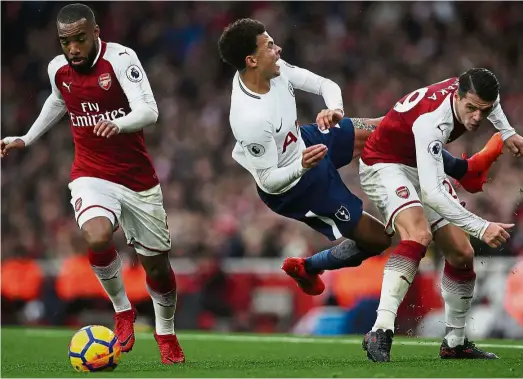  ?? 0. — AFP ?? Real or faking
it?: Tottenham’s Dele Alli (centre) falling after clashing with Arsenal’s Granit Xhaka (right) in the Premier League match at the Emirates last November. Arsenal won the match 2-
