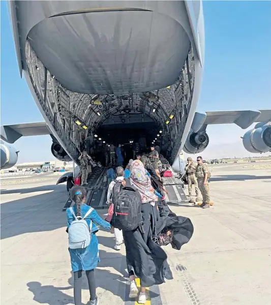  ??  ?? Khalida Sedeqey holds daughter Sowayba’s hand as they board Globemaste­r aircraft at Kabul airport on Friday afternoon