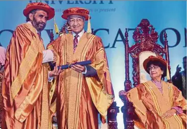  ?? BERNAMA PIC ?? Perdana University ProChancel­lor Tan Sri Dr Mohan Swami conferring an honorary doctor of philosophy on Prime Minister Tun Dr Mahathir Mohamad in Serdang yesterday. With them is Dr Mahathir’s wife, Tun Dr Siti Hasmah Mohd Ali.