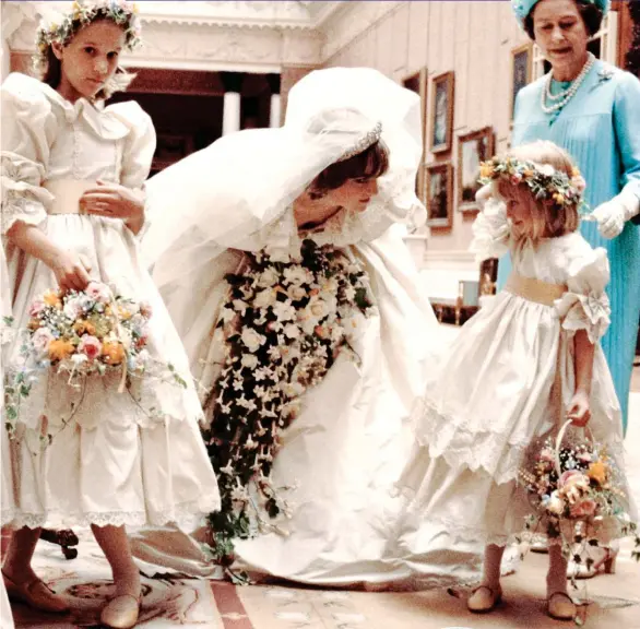  ??  ?? TENDER MOMENT: Diana leans down to smile at little Clemmie Hambro as she, her fellow bridesmaid SarahJane Gaselee, left, the bride and the Queen head to the official photo call. Right: Diana and Charles arriving at Buckingham Palace after the service