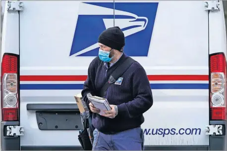  ??  ?? Postal carrier Josiah Morse heads out to deliver mail and packages Wednesday in Portland, Maine. The U.S. Postal Service's stretch of challenges didn't end with the November general election and tens of millions of mail-in votes. The pandemic-depleted workforce fell further into a hole during the holiday rush, leading to long hours and a mountain of delayed mail. [ROBERT F. BUKATY/ THE ASSOCIATED PRESS]