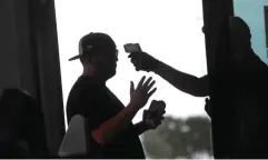  ?? LM Otero/Associated Press ?? ■ Amid concerns of the spread of the virus that causes COVID-19, a baseball fan has his temperatur­e checked by a security guard before being allowed to tour Globe Life Field, home of the Texas Rangers, on June 1 in Arlington, Texas.