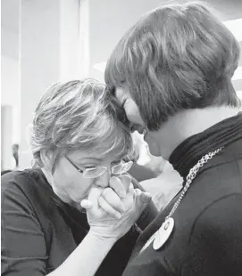  ?? CHRIS YOUNG/AP 2015 ?? Wanda Morris, left, former CEO of Dying with Dignity Canada, embraces colleague Anya Colangelo at the group’s offices in Toronto after Canada’s highest court struck down a ban on doctor-assisted suicide for mentally competent patients with terminal illnesses.