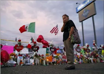  ?? JOHN LOCHER — THE ASSOCIATED PRESS ?? Catalina Saenz wipes tears from her face as she visits a makeshift memorial near the scene of a mass shooting at a shopping complex Tuesday in El Paso, Texas. A list of the people who died in the weekend shooting rampage at the Walmart shows that most of the victims had Latino surnames and included one German national.