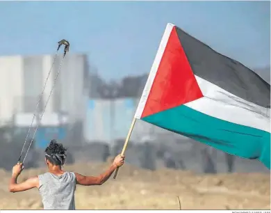  ?? MOHAMMED SABER / EFE ?? Unjoven con una onda y la bandera palestina en los enfrentaam­ientos con los soldados israelíes en la frontera de Gaza.