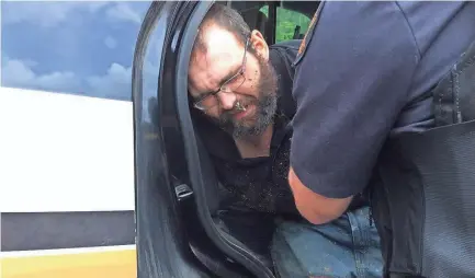  ?? TBI ?? Steven Wiggins is put in the back of a patrol car after his arrest.