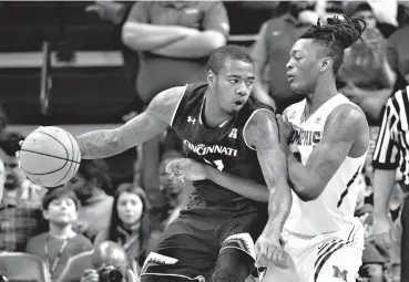  ??  ?? ■
Cincinnati forward Gary Clark, left, controls the ball against Memphis forward Kyvon Davenport during the first half of an NCAA college basketball game Saturday in Memphis, Tenn.
Associated Press