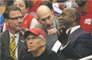  ?? ASSOCIATED PRESS FILE PHOTO ?? NBA Commission­er Adam Silver, center, talks with Magic Johnson, right, as Kiki Vandeweghe, NBA executive vice president for basketball operations, looks on as they watch the Clippers play the Thunder in a 2014 semifinal. The NBA will experiment with a...