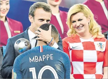  ?? FOTO: AP ?? El presidente francés, Macron, le da el título de mejor joven a Mbappé ante la sonriente presidenta de Croacia, Kolinda Grabar-Kitarovic