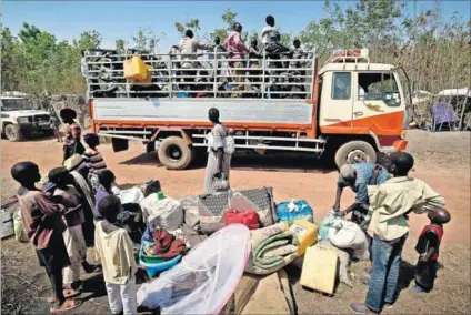  ?? Photos: Frederic Noy ?? New arrivals: The Matiop family gather their luggage after being dropped off at the Nyumanzi settlement in Uganda. The father of the 15-member family, which includes his six children, his mother and his sister and her five children, was a community...