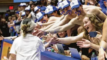  ?? BEN MCKEOWN PHOTOS / AP ?? Samantha DiMartino, 10, gets high-fives from fans in the Duke student section after being honored as a part of the Scheyer Family Kid Captains Program, which recognizes patients and families of Duke Children’s Hospital, during a timeout at a game Wednesday between Duke and Louisville in Durham, N.C.