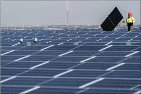  ?? AP FILE ?? Electricia­ns with IBEW Local 3 install solar panels on top of the Terminal B garage at Laguardia Airport, on Nov. 9, in the Queens borough of New York. President Biden plans to invoke the Defense Production Act to increase U.S. manufactur­ing of solar panels while declaring a two-year tariff exemption on panels from Southeast Asia.