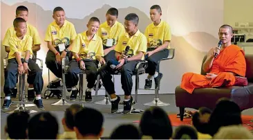  ?? AP ?? Ekapol Chantawong, right, former coach of the Wild Boars soccer team, speaks during a public discussion in Bangkok last week. Members of the Wild Boars soccer team, on stage, spoke at an exhibition at one of Bangkok’s largest shopping malls, about their ordeal of being trapped for almost three weeks in a flooded cave.